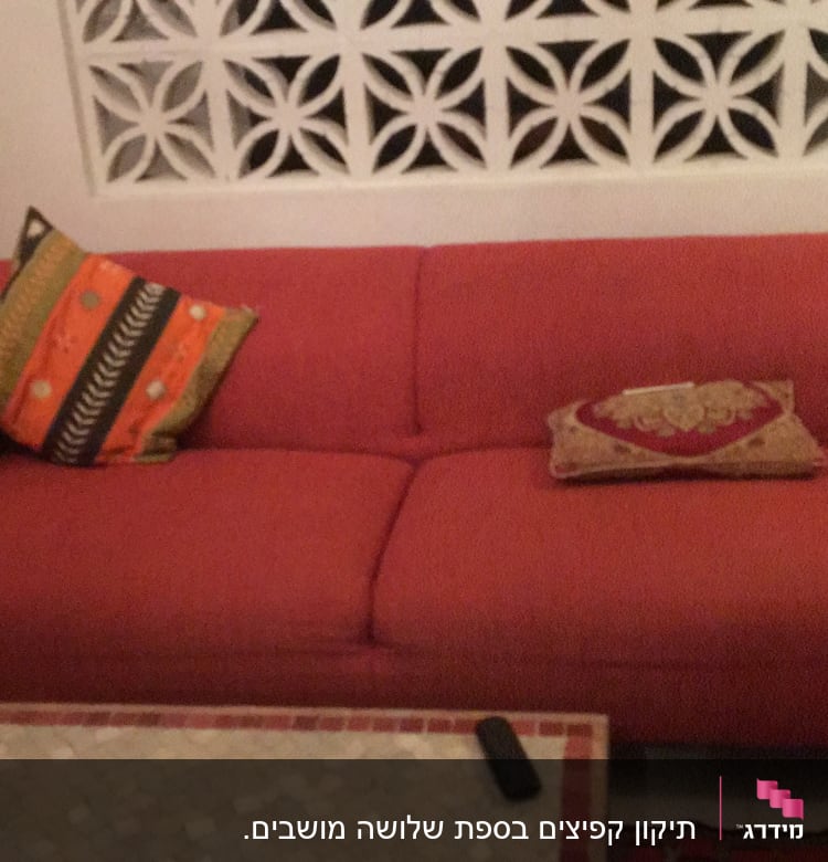 ספה אדומה עם כריות צבעוניות על מושביה